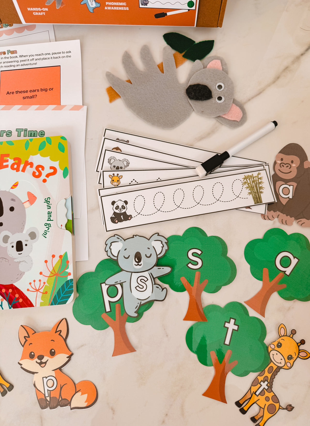 Educational materials for children including flashcards, a koala toy, and alphabet cards on a surface.