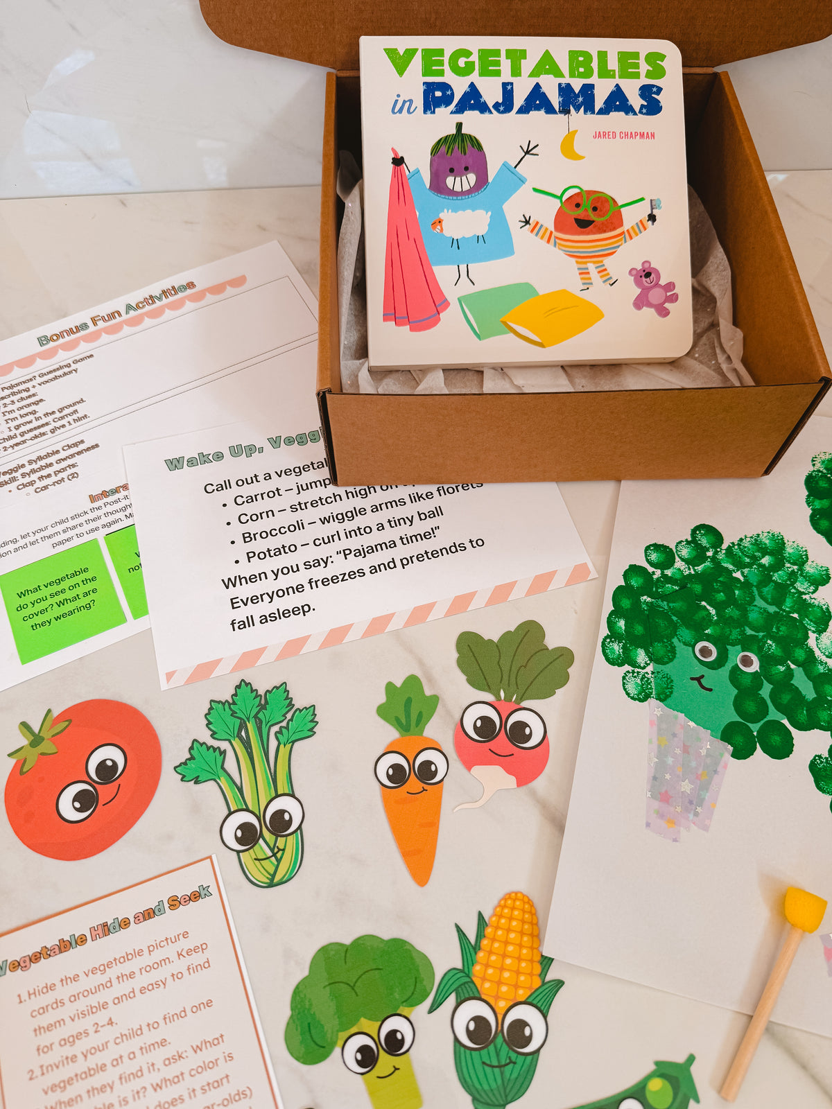 Children's book titled 'Vegetables in Pajamas' with educational materials on a white surface.