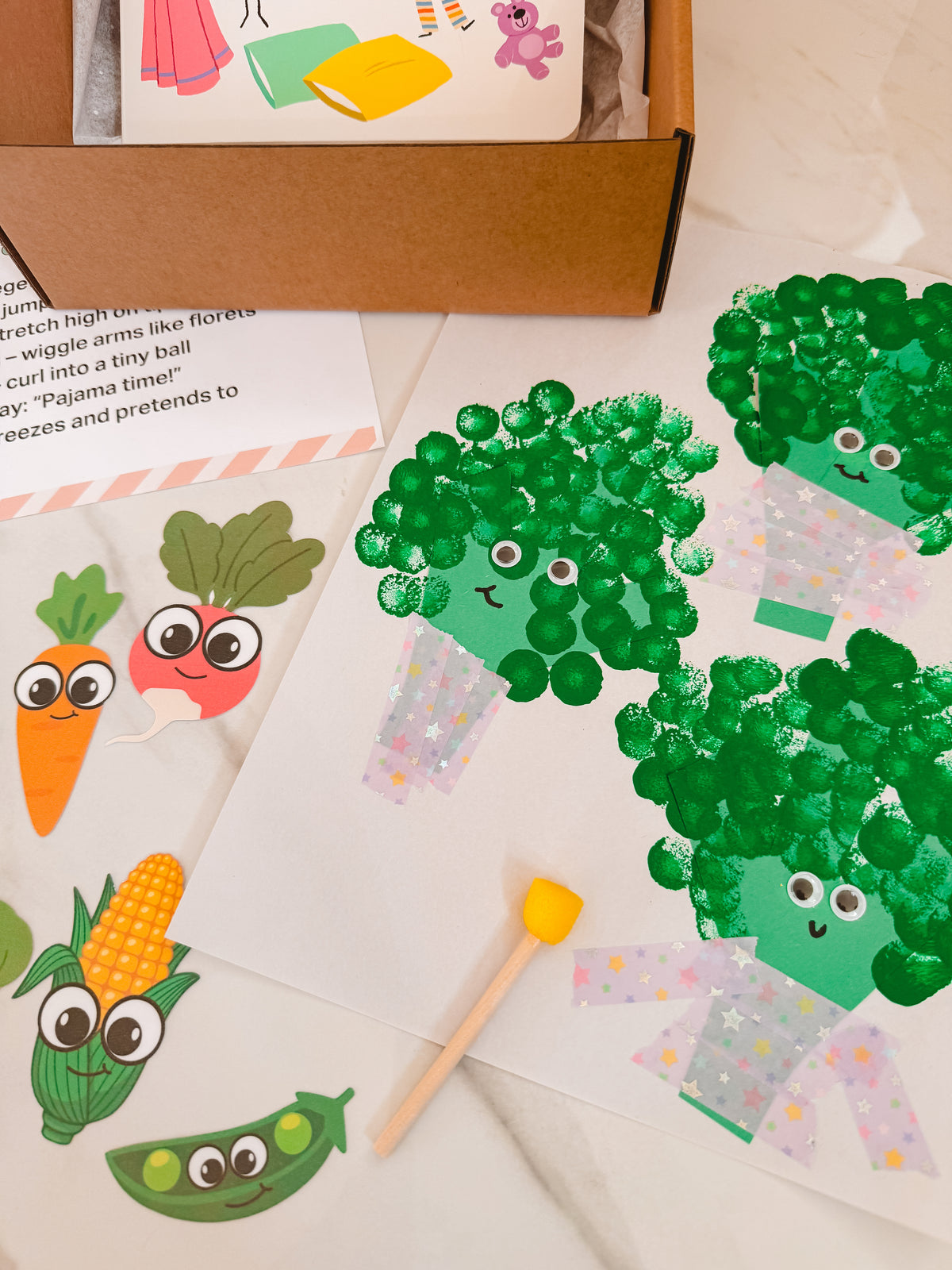 Children's craft project with green broccoli-like figures made from paper and pom-poms.